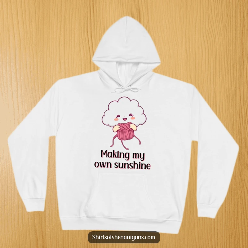 Funny Hoodie: Cheerful cloud knitting a rainbow, a cozy and humorous piece of clothing.