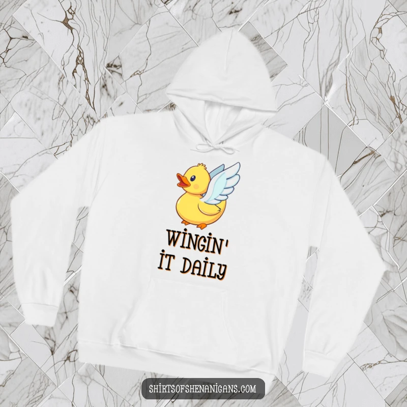 Funny rubber duck with its tiny wings furiously flapping, trying to fly, on a soft, warm hoodie.