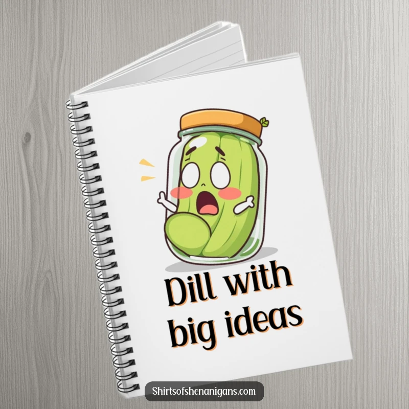 Funny shocked pickle rolling out of a jar, looking surprised, on the cover of a spiral-bound notebook.
