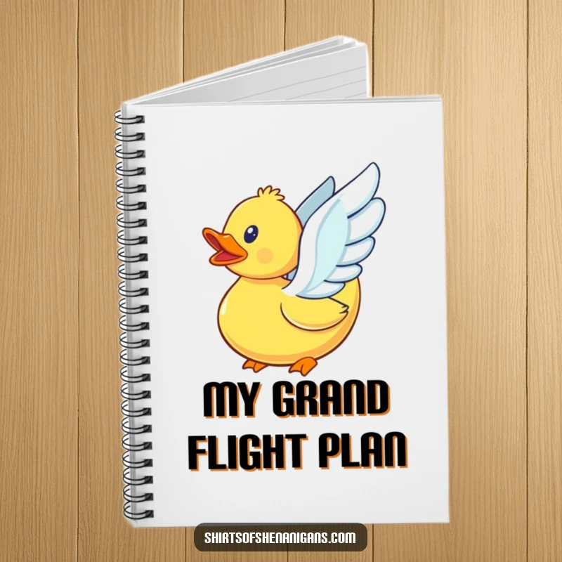 Funny rubber duck with its small wings beating, attempting to fly, on the cover of a spiral-bound notebook.