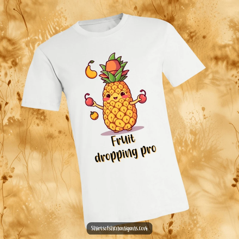 Funny T-Shirt with a juggling pineapple in a small hat comically dropping its fruit, showing a flustered expression.