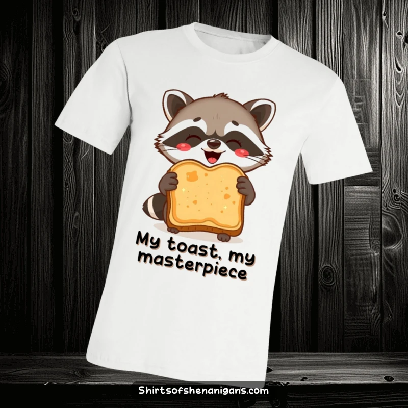 Funny T-Shirt: A delighted raccoon proudly holds a burnt slice of toast, a symbol of breakfast success.