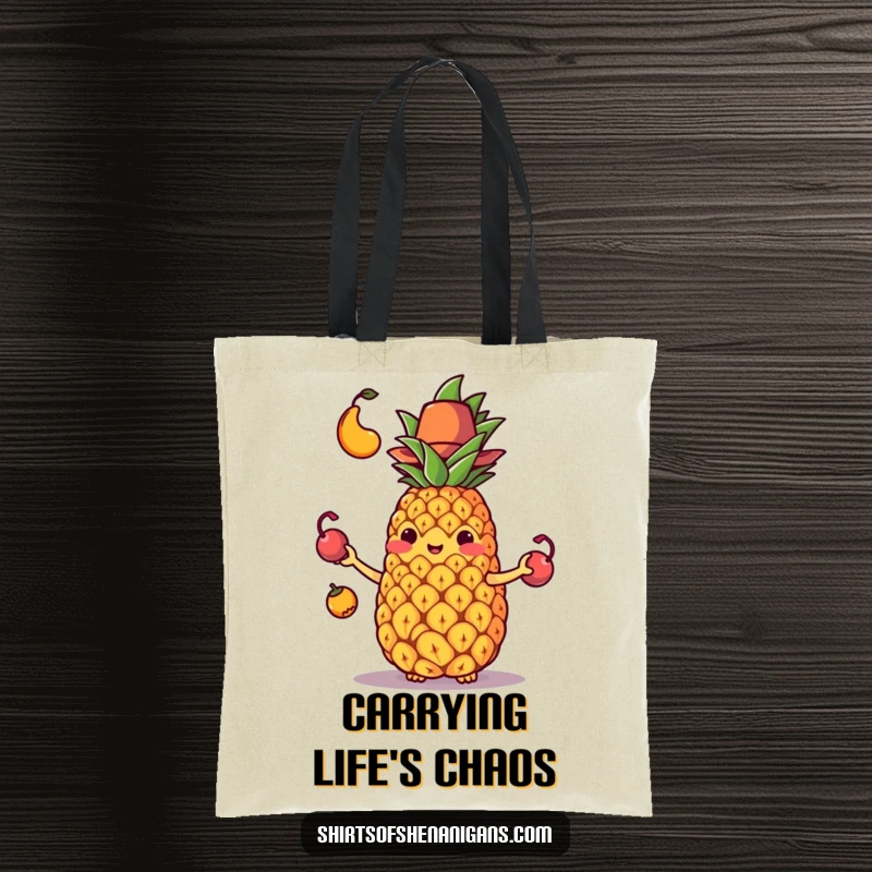 Funny tote bag showcasing a pineapple struggling to juggle its fruit while wearing a tiny hat, a comical mishap.